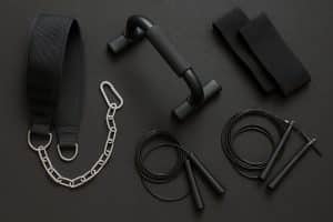 Calisthenics accessories including resistance bands, pull-up bar, parallettes, and gymnastic rings